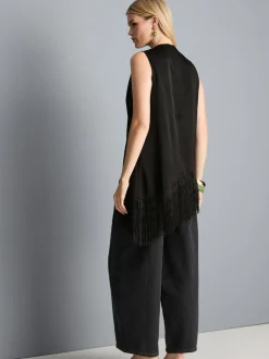 Blusa asimétrica con flecos y cuello drapeado