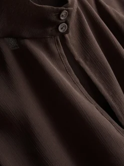 Blusa de cuello alto con capa