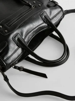 Bolso con asa superior y detalle de hebilla